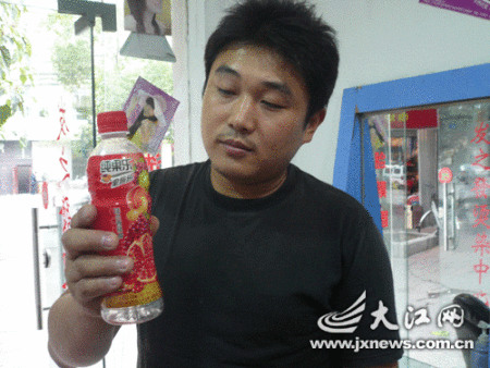 王先生拿著女兒喝過的“問題”飲料。